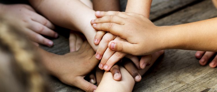 A child's hands held gently in an adult's
